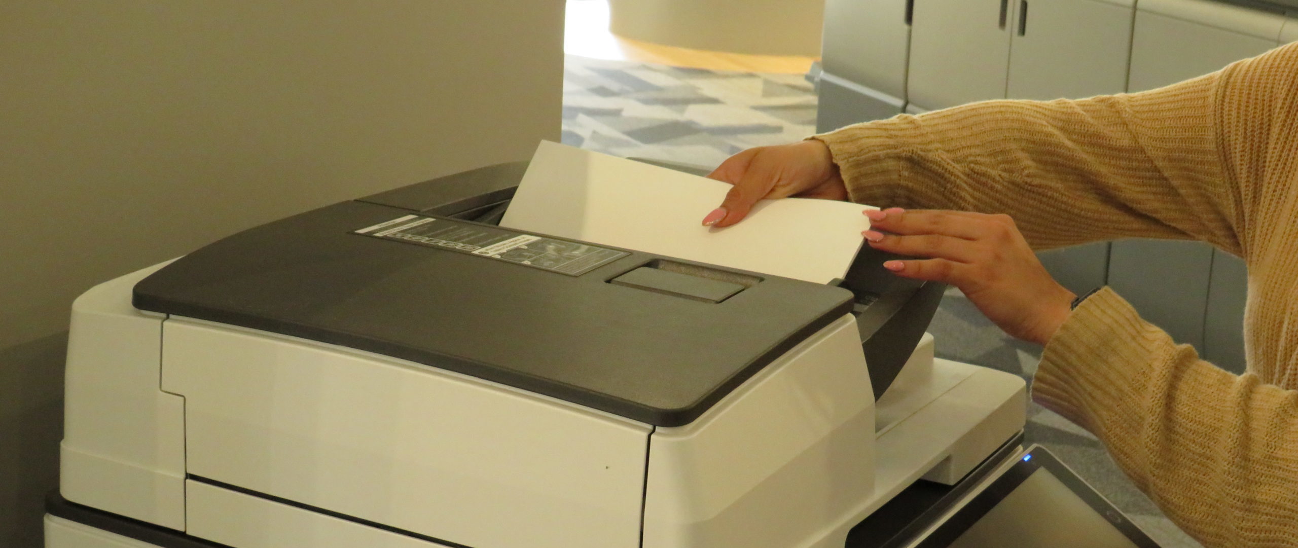 A woman putting paper in the printer