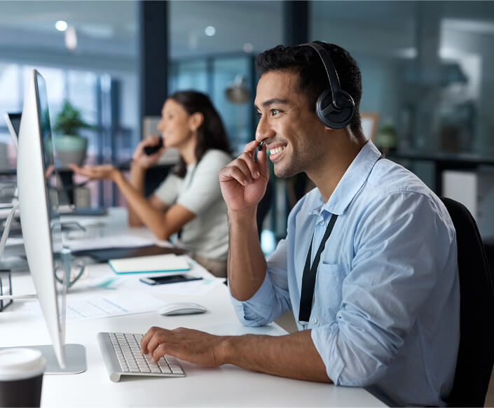 People with headsets sitting at their computers