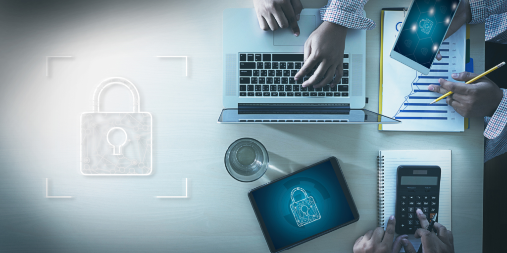 overhead conceptual shot of security with a laptop, charts, and calculator on the table