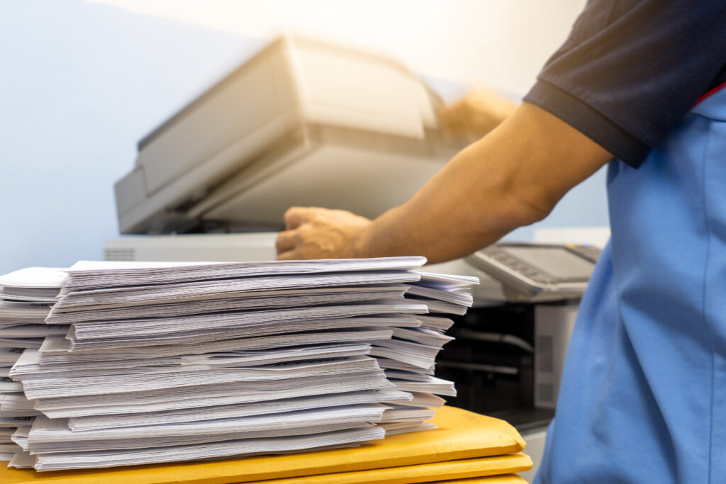 A large stack of papers waiting to be scanned signifying document scanning services.