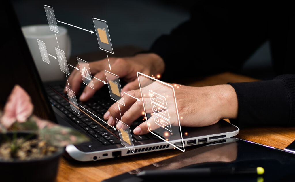 A person is working on a laptop with graphic overlays showing a flowchart of digital documents, representing the integration and ease of use of a document management system in a modern workplace.