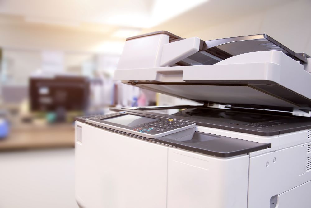 A close up of a multifunction printer in an office setting.