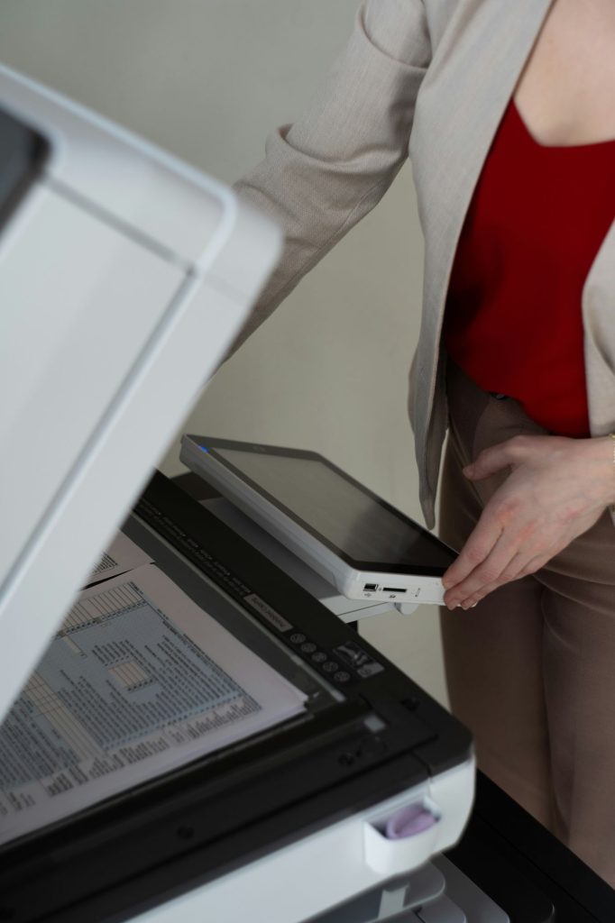 Person scanning a document on a multifunction printer