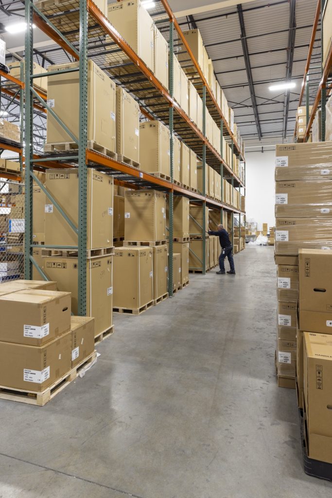 Tall warehouse shelves stocked with boxed supplies