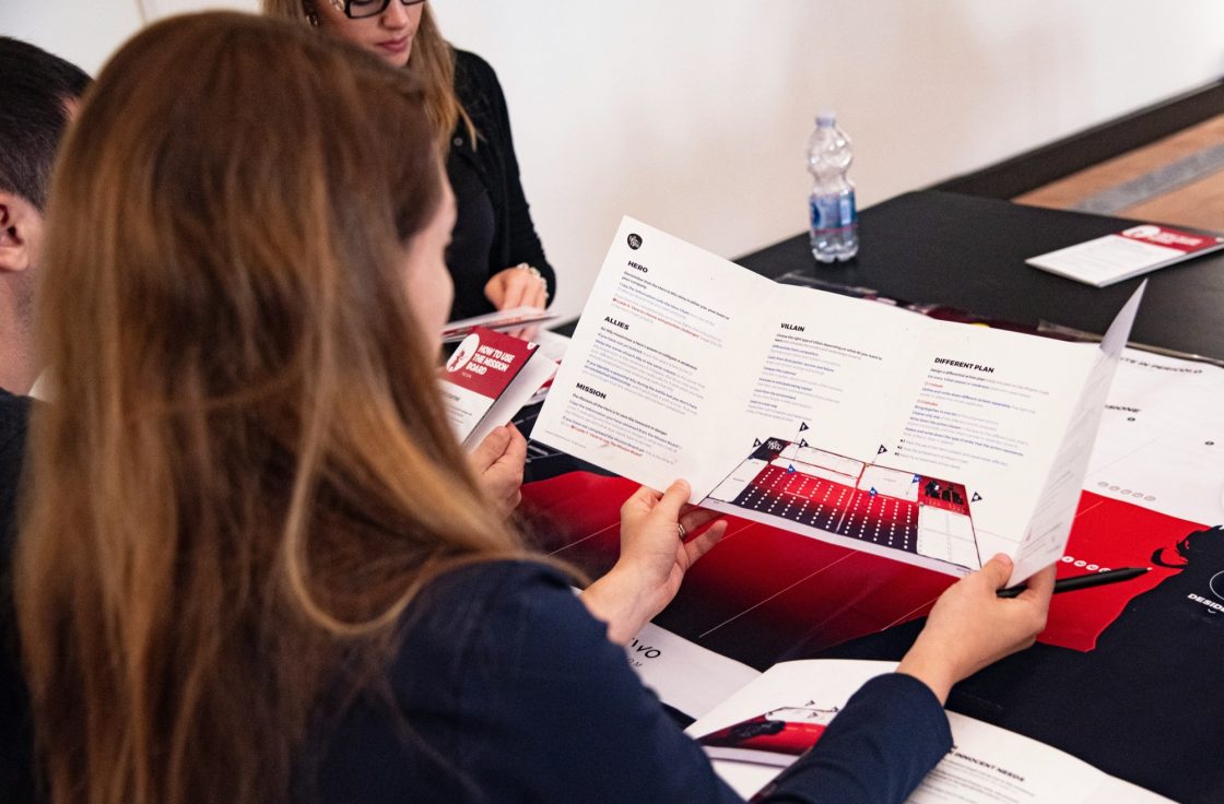 Colleagues reviewing a printed product guide at a table