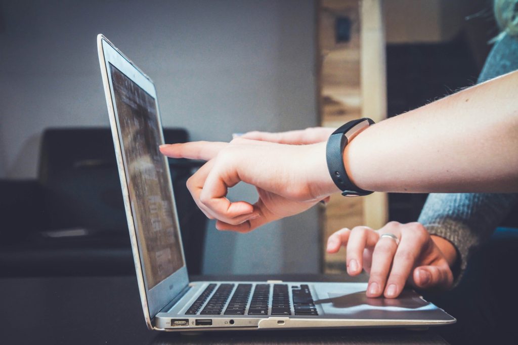 Colleagues pointing at a laptop screen while troubleshooting together