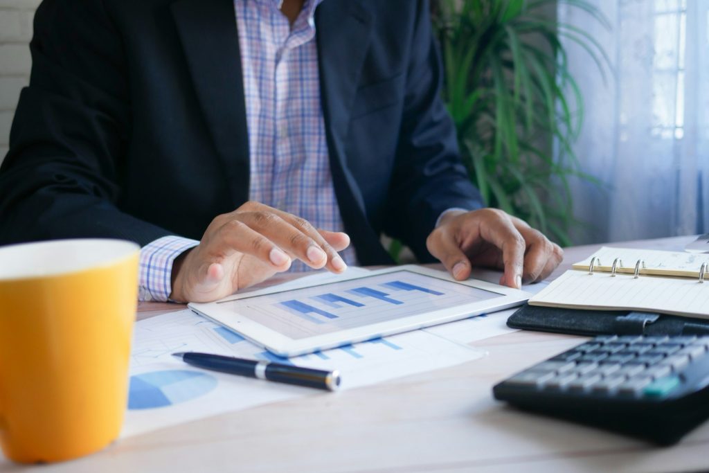Advisor reviewing financial charts on a tablet beside a calculator