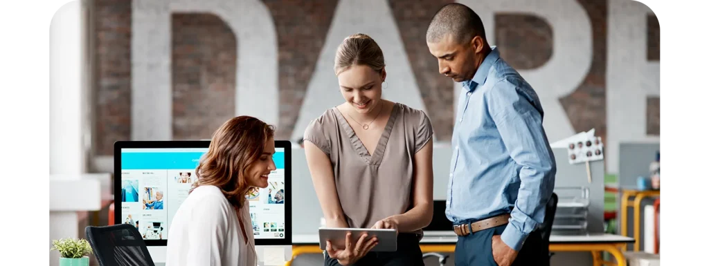 Colleagues reviewing documents on a tablet at a workstation