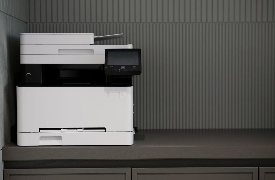 Compact desktop color laser printer on an office cabinet