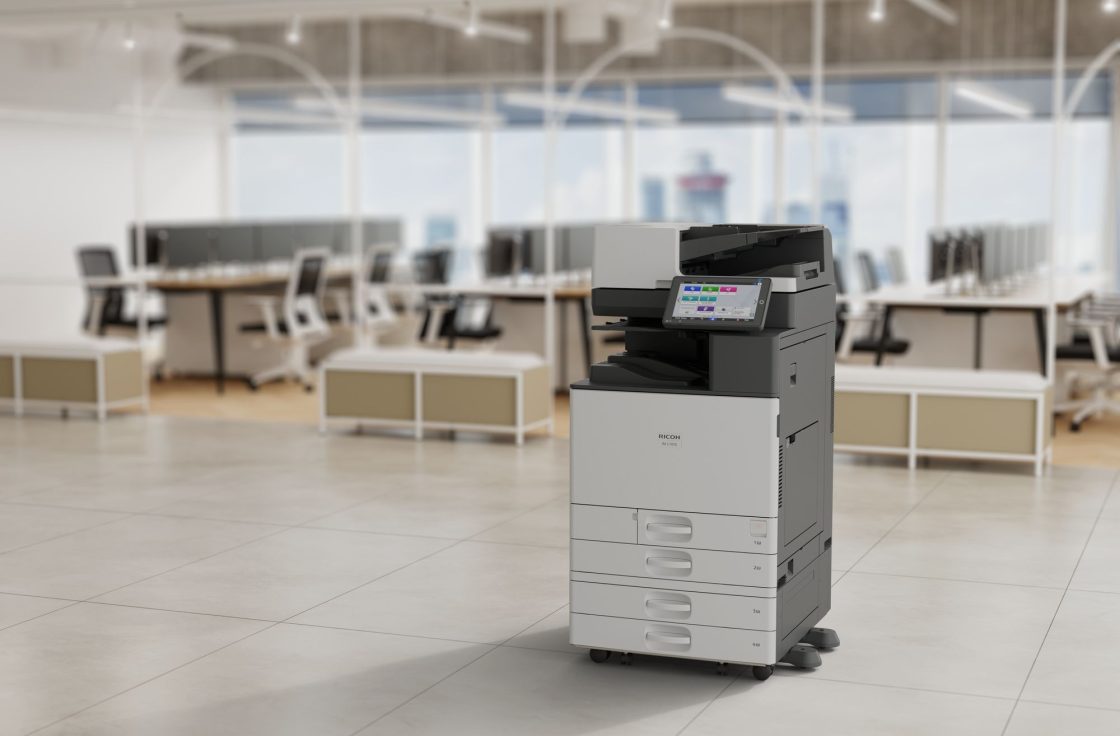 Ricoh IM C7010 multifunction printer with finisher in an open office