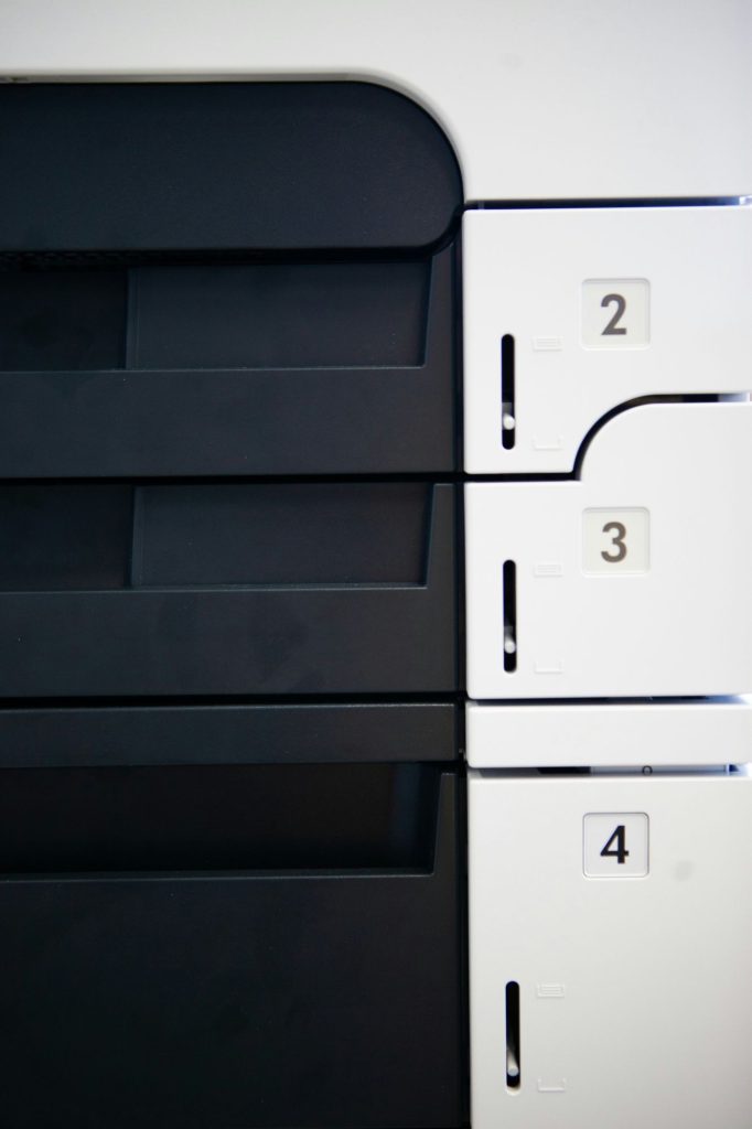 Close-up of numbered paper trays on a desktop printer