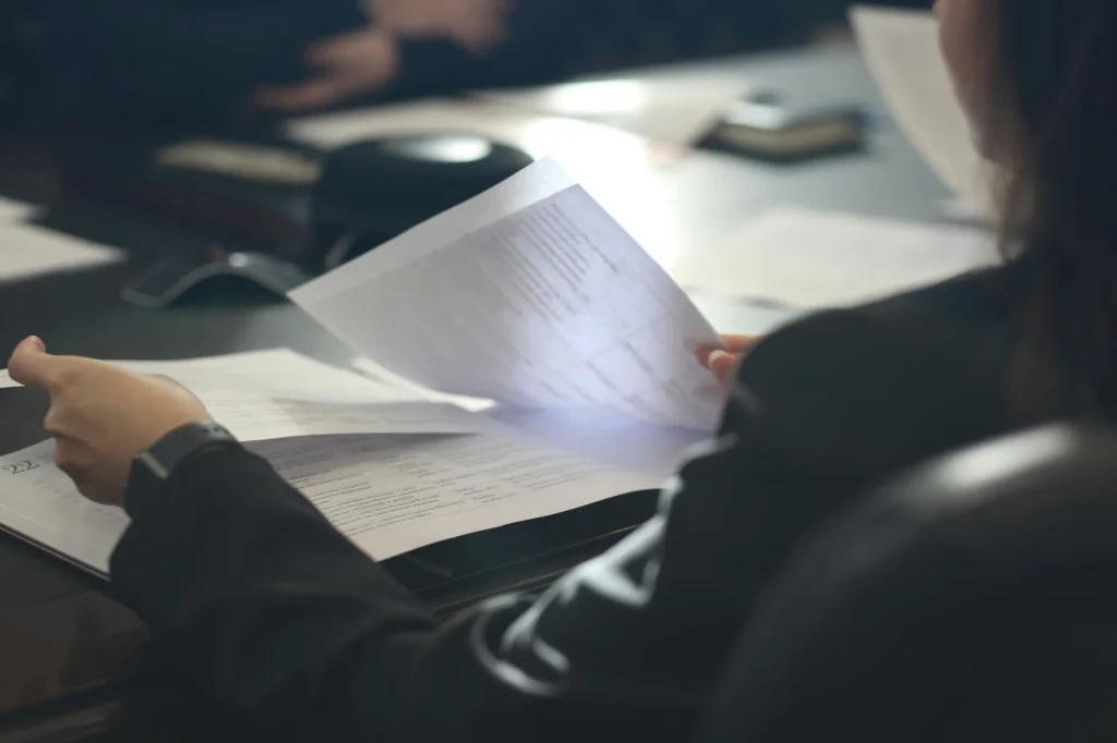 Person reviewing printed documents at a desk