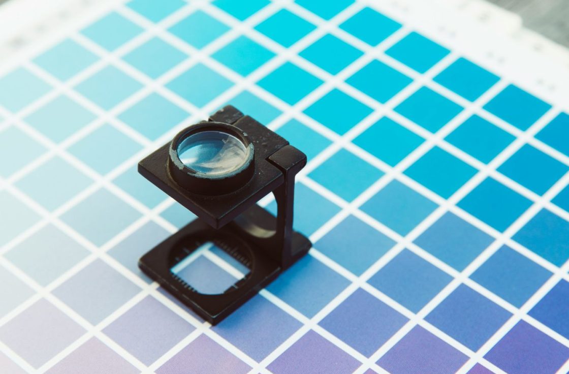 Loupe resting on a printed color calibration chart