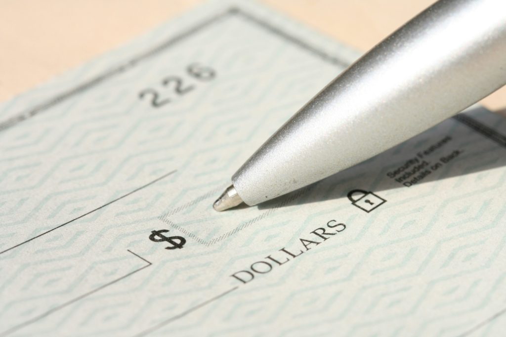 Pen filling in the amount on a check