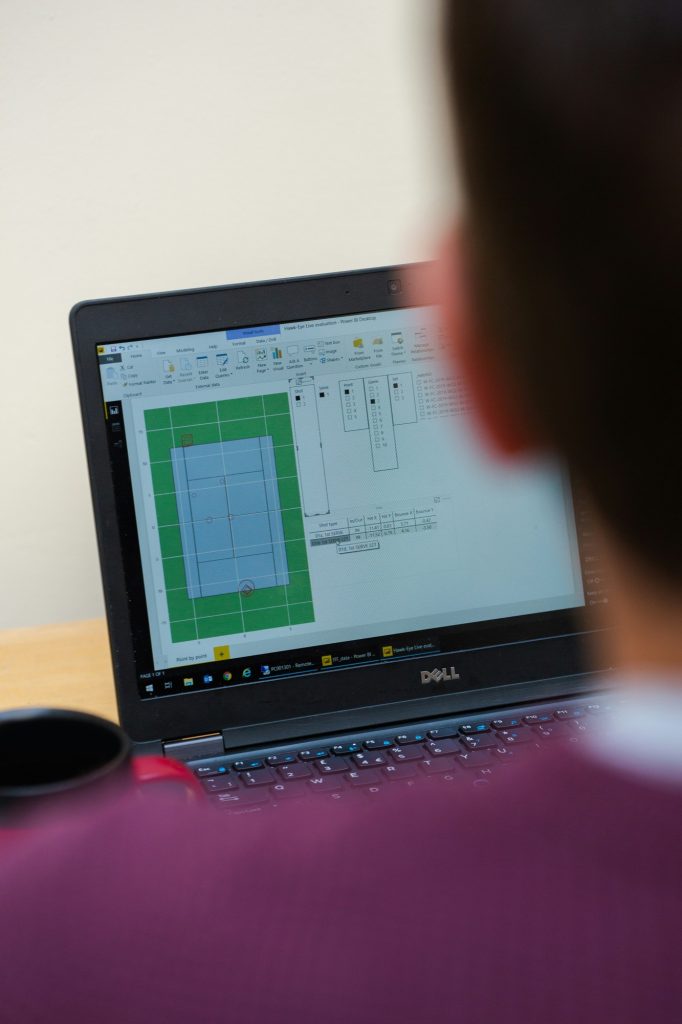 Person working on a laptop showing a spreadsheet
