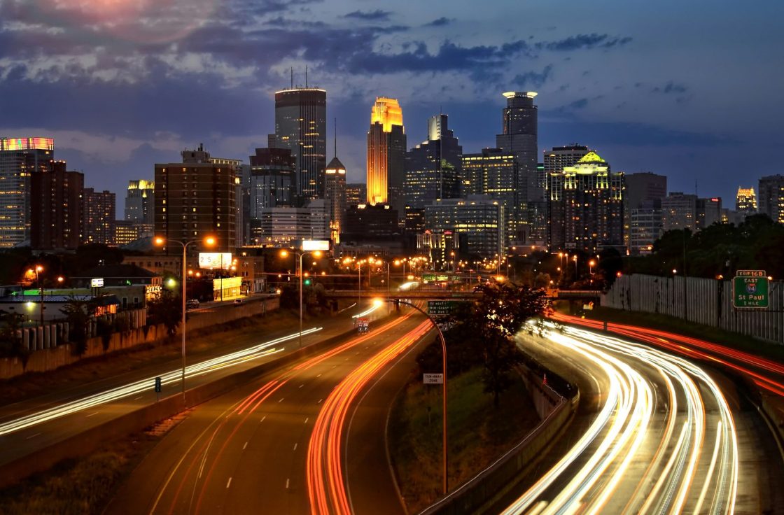 Minneapolis skyline at night with highway light trails